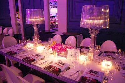 Purple orchids, candles, and Bourgie table lamps, designed by Ferruccio Laviani for Kartell, topped tables in the dining room.