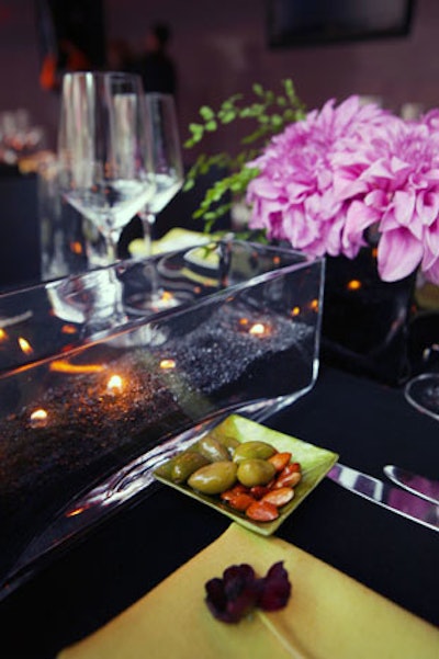 Black sand and candles filled glass vessels on tabletops.