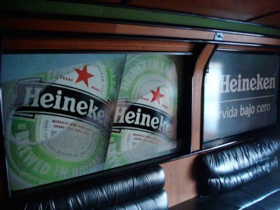 The Heineken logo and Extra Cold slogan in Spanish—meaning 'Serve Below Zero'—adorned the walls inside the lounge area of the bus.
