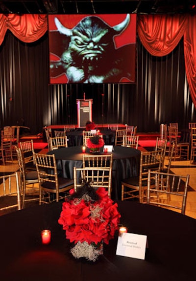 Table centerpieces included red roses topped by black feathers.