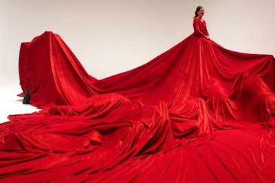 Members of the public were invited to crawl under the red dress worn by a woman in 'A Sultry World.'