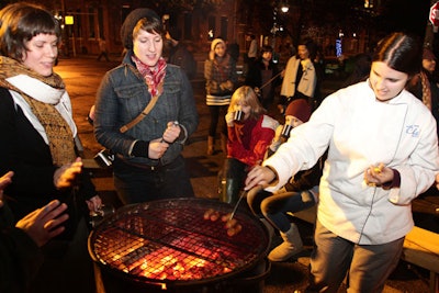 Members of the public congregated around fires and sampled rations of sausages and hot chocolate as part of Tom Dean's 'Fire and Sausage' installation in Liberty Village.