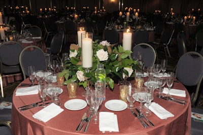 Heffernan Morgan topped dinner tables with hurricane candles, pink roses, and magnolia leaves.