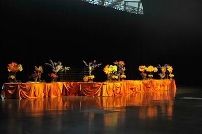 Floral arrangements and orange linens topped a table used to display desserts from the Cupcake Shoppe and Enchanted Sweets during the after-party.