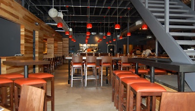 Masa's decor includes exposed brick walls, natural wood, concrete floors, and red glass pendant lamps.