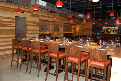 The 100-seat main dining room includes a communal table for 12 and a view of the open kitchen.