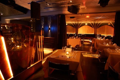 The DJ booth sits at the edge of the brown, gold, and black main dining space.