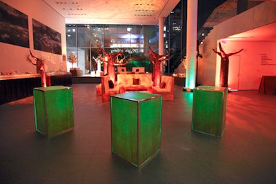 Illuminated cocktail tables and leaf-patterned projections added warmth to the dimly lit space.