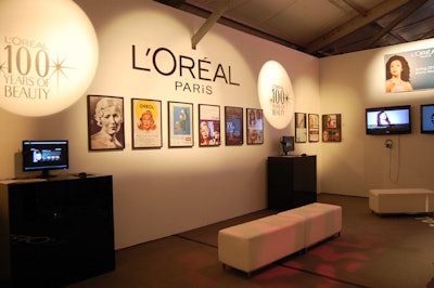 Vintage advertisements and displays of iconic products are showcased in the L'Oréal Paris lounge.