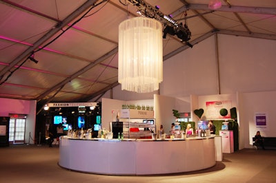 An oversize chandelier dressed in a white fringe hangs above the main bar in the Fashion Environment tent.