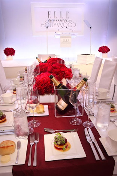Burgundy table runners and Moet bottles in Lucite ice boxes topped high-gloss white tables.