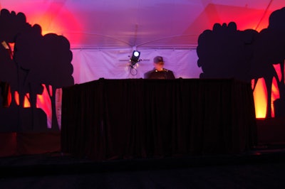 To establish the twilight motif, tree silhouettes and a contrast of orange and blue lighting marked the perimeter of the dinner tent.