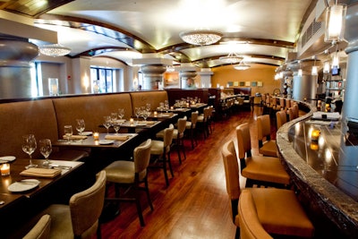 Beige upholstered chairs line the stone-accented bar.