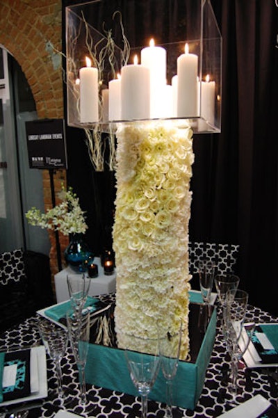 Lindsay Landman Events used graphic black-and-white linens with touches of turquoise. A tall floral column topped with a clear cube full of candles served as a striking centerpiece.