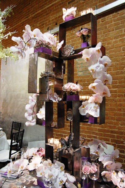 Floral Icon Events gave an industrial-looking metal sculpture a soft, elegant feel by covering it with candles, blooms, and succulents in soft shades of gray, white, and lavender.