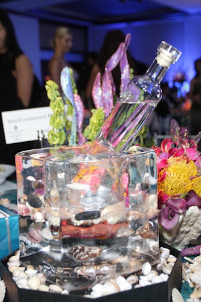 Bruce Sutka created centerpieces of glass vases filled with seashells and water and surrounded by glittery coral.