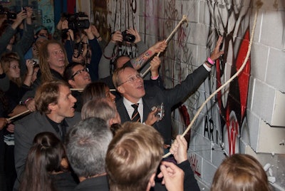 Attendees, artists, speakers, and planners all helped to pull down the ceremonial wall during the public portion of the event.