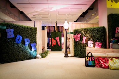 To divide and decorate the corporate conference room, Patrick Martinez used fabric walls, hedges, and lamps marked with street signs.