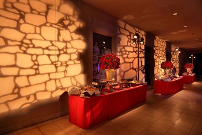A lighting pattern that resembled Italian stonework brightened the walls over Wolfgang Puck's buffet tables, topped with urns of giant red roses.