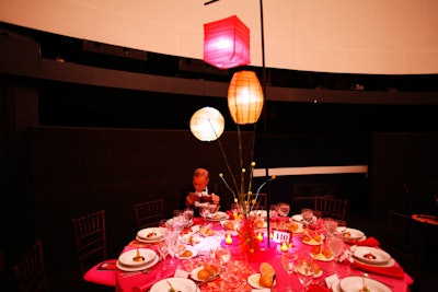 A third tabletop design incorporated fuchsia linens with Kente-cloth runners, yellow Billy balls, and centerpieces with three illuminated lanterns.