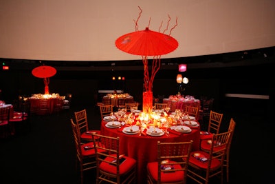 Oversize paper umbrellas and twisted red branches decorated some tables.