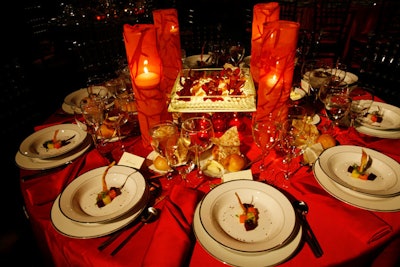 A second tabletop design included mirrored light boxes topped with clear glass trays of burgundy orchids, red votive candles, and glass cylinders wrapped in patterned fabric.