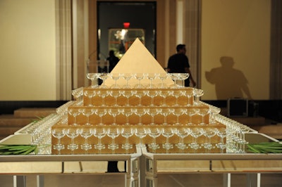 Champagne glasses surrounded a gold pyramid on display in Walker Court.