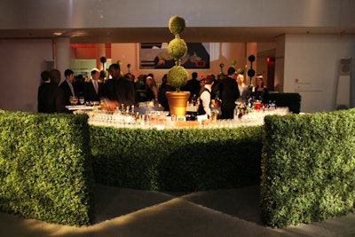 Hedges and topiaries inspired by Burton films Edward Scissorhands and the upcoming Alice in Wonderland surrounded a bar.
