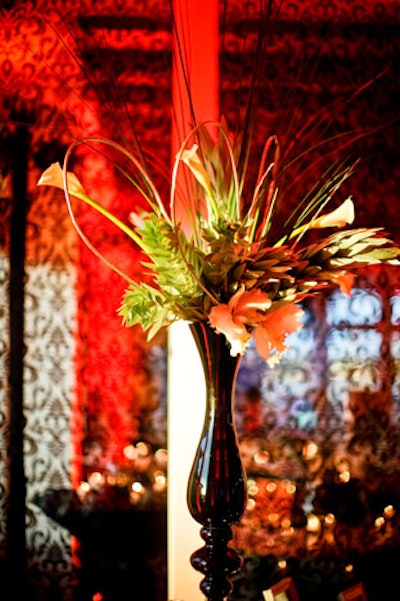 At the registration desk, a narrow black vase held cattleya orchids, silver tree protea, and steel grass.