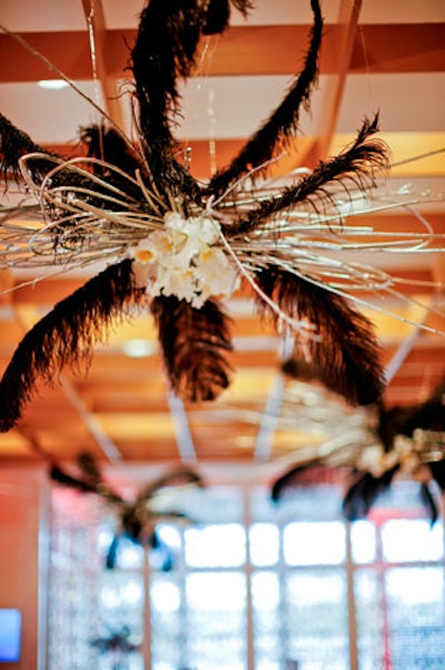 Revel Decor created custom chandeliers with black feathers and white cattleya orchids.