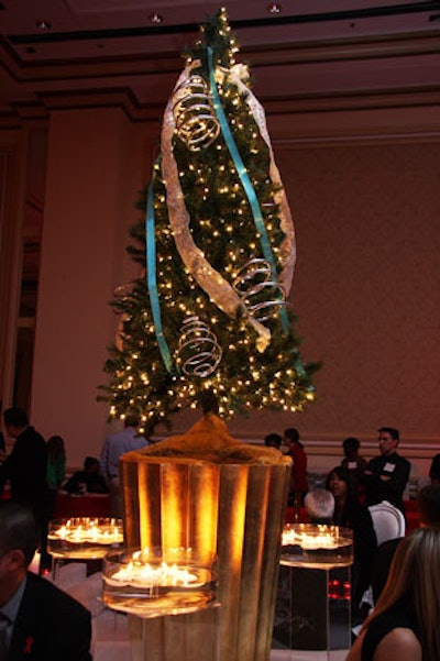 Kehoe topped golden pedestals with decorated Christmas trees; around the trees, votive candles floated in clear vessels.