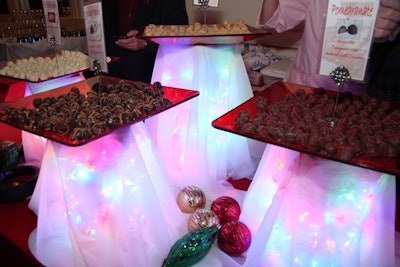 Cyndy's Sweet Treats presented pomegranate, eggnog, and peach truffles on stands that were strung up with Christmas lights and draped with translucent fabric.