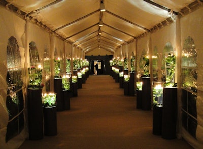Heffernan Morgan lined U.S. Event Structure's 110-foot-long tented hallway—leading guests from the East Wing to the dining tent—with pedestals and illuminated glass vases filled with fresh cut ivy and orchid stems.
