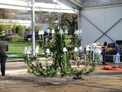 A total of 12 electric chandeliers with lampshades from Frost's Washington branch hung from the tent's ceiling, three of which were 8 feet in diameter and nine of which were 5 feet across. Florist Laura Dowling spiraled freshly cut ivy around the arms.