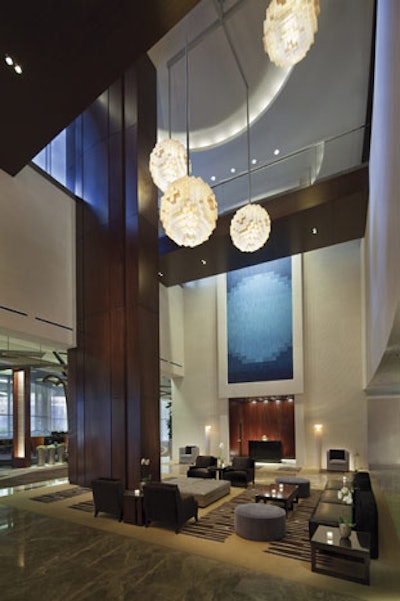 The concierge lobby has high ceilings and dark wood detailing.