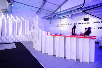 Designer and architect Greg Lynn created the Designers ' Lounge, sponsored by HSBC, with white furniture and an interconnecting folding panel wall that separates it from the main exhibition areas.