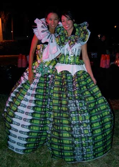 Two models wearing dresses branded with images of liquor sponsor Grolsch's beer bottles posed for pictures at it's table at Vanity Fair International's party at the Museum of Contemporary Art.