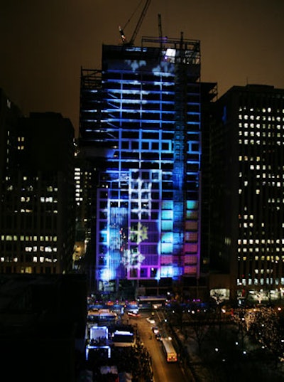 As the final beam was lifted into place, Event Architects' light show illuminated the new building's framework with colors and snowflake projections.