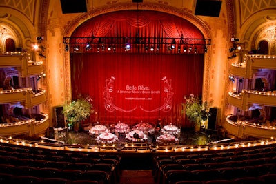 Guests arrived to see half of the dinner area on the stage concealed by a curtain covered in a projection of the benefit's name.