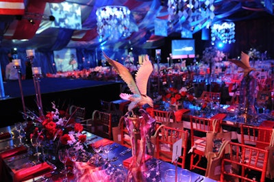 Red and white floral centerpieces, American flag-printed ribbon, and gold statues of bald eagles topped each of the dinner tables.