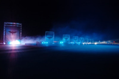 Giant panels bearing Virgin Galactic marketing imagery lit up as the shuttle moved toward the guests.