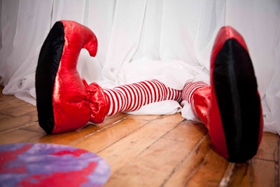 A pair of legs dressed in red-and-white-striped tights and shiny red shoes, stuck out from the bottom of a wall in the candy room.