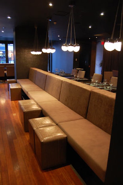 The restaurant features an earthy palette, with hardwood floors, taupe banquettes, and dark walls.