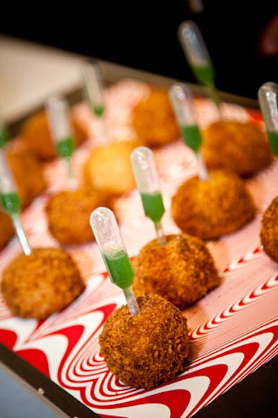 Hors d'oeuvres like caramelized sweet potato truffles with kiwi ginger injection were served on trays covered in op art images.