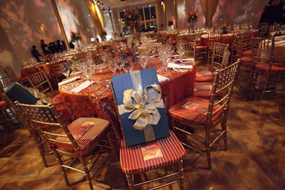 Marc Chagall's 'Paris Opera Ceiling Mural' inspired the tables' red, orange and gold color scheme, with gold bamboo chairs and tablecloths in both textured metallic gold and red damask.