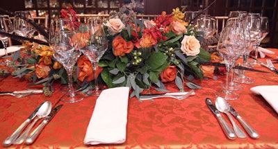 High and low floral arrangements by Jack H. Lucky Floral Design included feathers, berries, and birch branches, in addition to roses and orchids in colors pulled from the Chagall painting.
