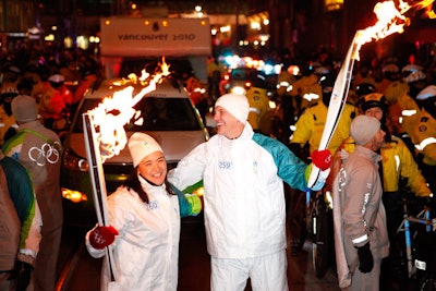 Jay Triano passed the Olympic flame to Vicky Sunohara, who carried the torch into Nathan Phillips Square.