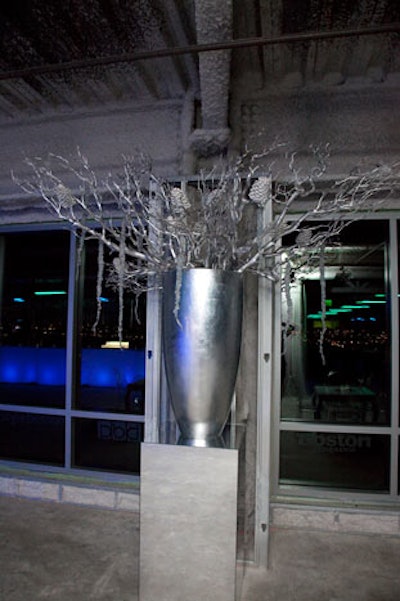 In lieu of poinsettias, Winston Flowers created four arrangements of silver-painted Manzanita branches in four-foot-tall silver vessels.