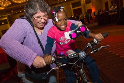 At the end of the afternoon, children from the Chicago Youth Centers entered the ballroom to claim their bikes; employees helped some kids learn to ride.