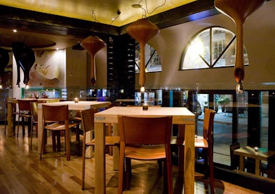 Custom butcher block tables and teak light fixtures fill the dining room at Ciao Wine Bar.